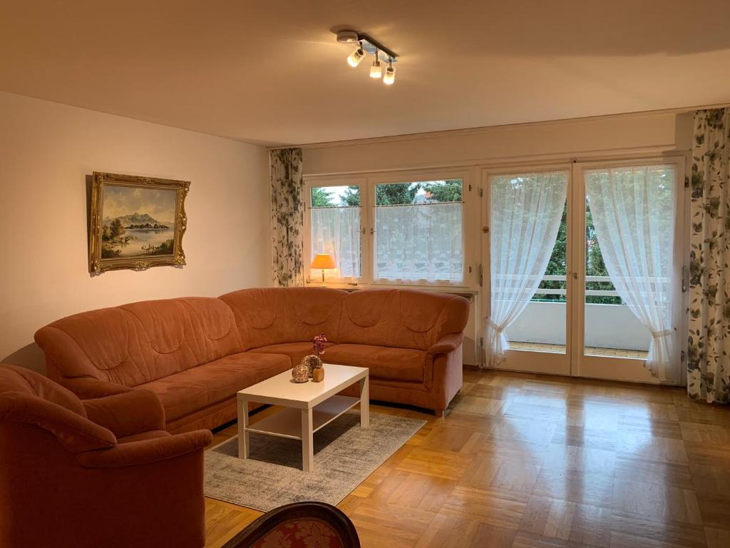 ein Wohnzimmer mit einem Sofa und einem Tisch in der Unterkunft Exklusive Lage, sehr große Wohnung mit Gartenblick - FEWO Hämmerle Rot in Konstanz