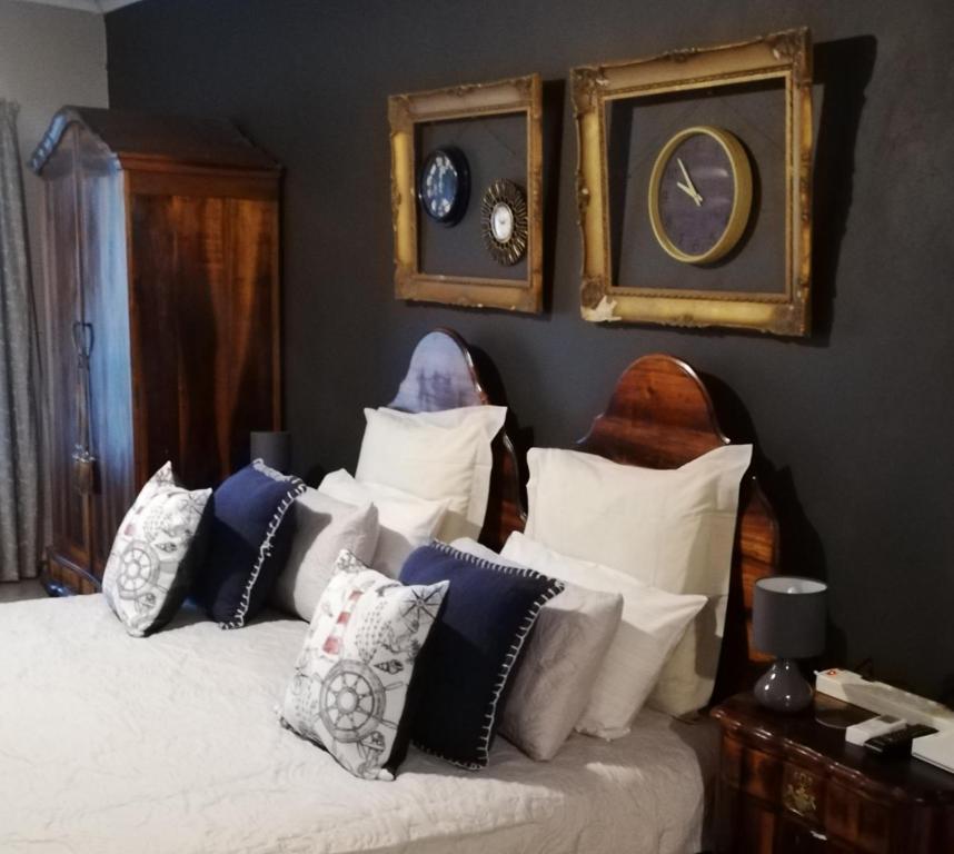 Un dormitorio con una cama con muchas almohadas. en A-Cody Place, en Louis Trichardt