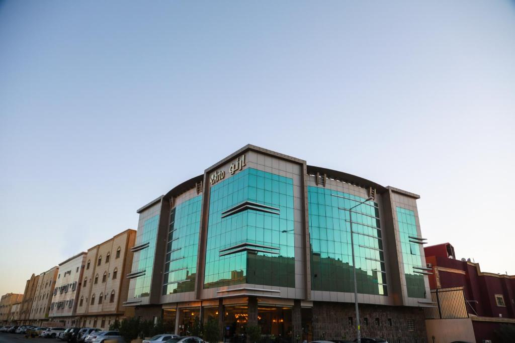 a glass building with cars parked in front of it at Arto Aparthotel in Riyadh