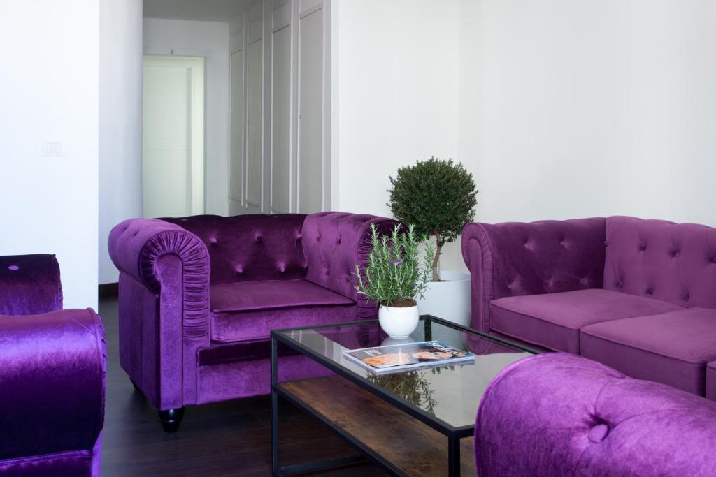 un soggiorno con divani viola e tavolo di Myrtus Guest House Cagliari a Cagliari