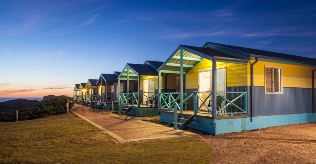 een rij huizen in een veld bij zonsondergang bij Dongara Tourist Park in Port Denison