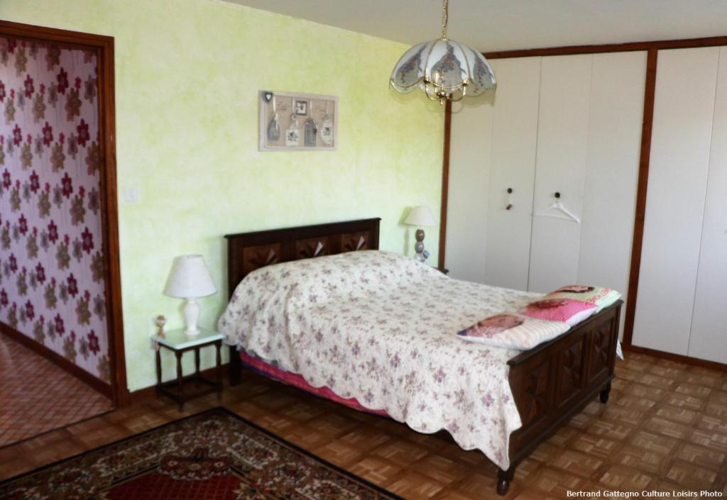 a bedroom with a bed and a table with a lamp at Horizon Aubrac Laguiole in Laguiole