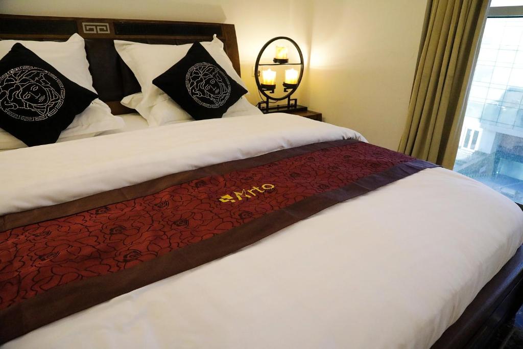 a bedroom with a large bed with black and white pillows at Arto Aparthotel in Riyadh