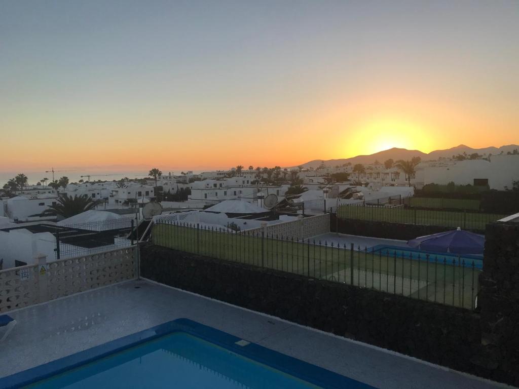 uma vista para o pôr-do-sol a partir da varanda de uma casa em Villas Vistabella em Puerto del Carmen
