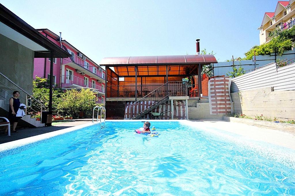 a person in the water in a swimming pool at Guest house Ameliya in Vardane