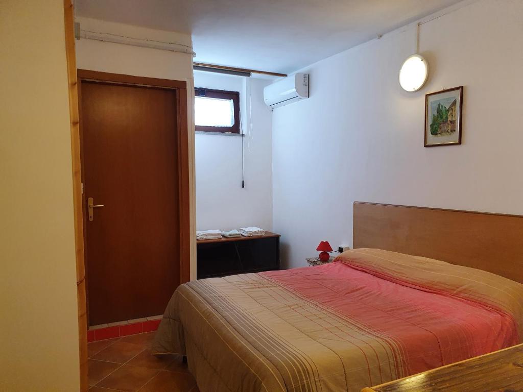 sypialnia z łóżkiem z czerwonym kocem w obiekcie Confortevole monolocale in villa w mieście Bracciano