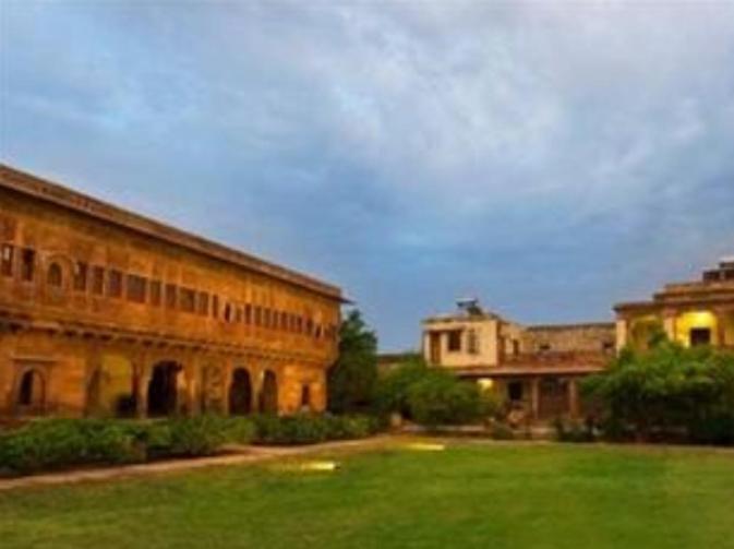 a large building with a green field in front of it at Chandelao Garh in Bīnāwās