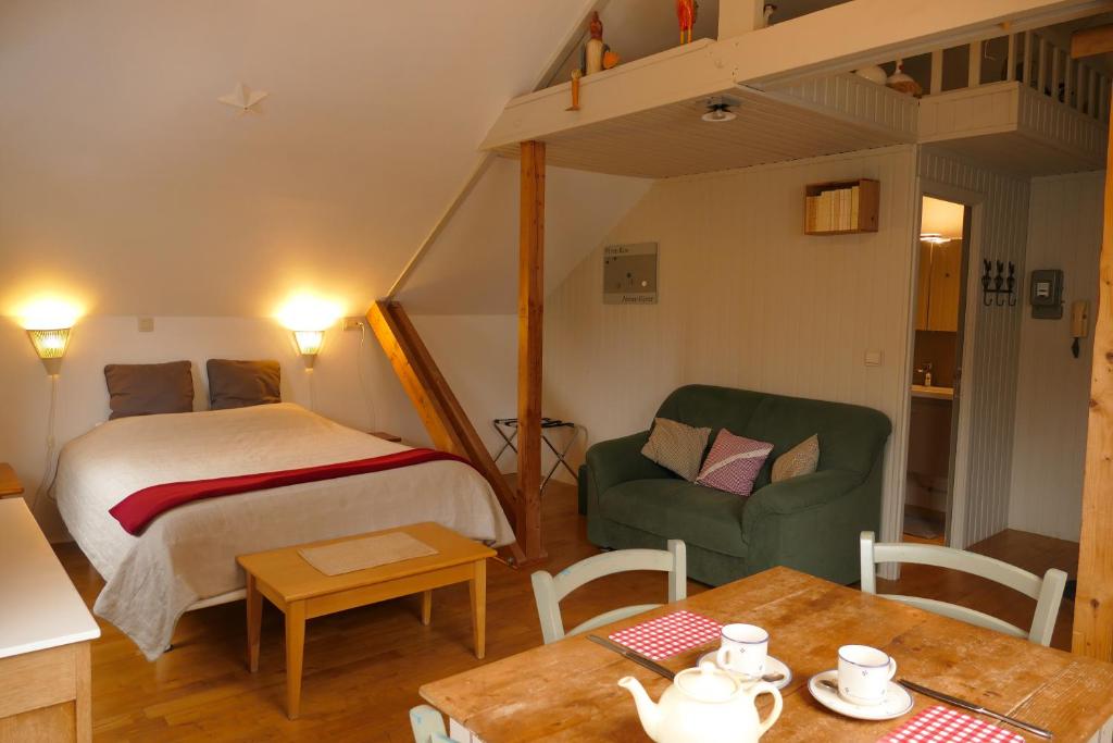 - une chambre avec un lit, une chaise et une table dans l'établissement La Pommeraie - Le Coin Ardenne, à Sainte-Ode