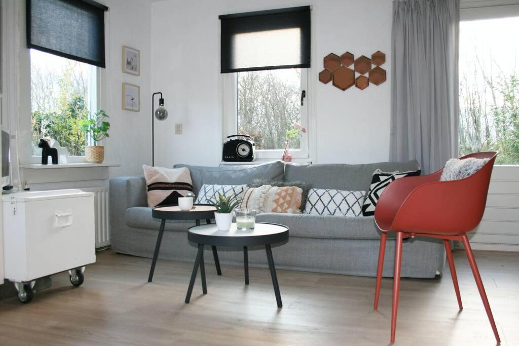 sala de estar con sofá y 2 mesas en Knus familiehuisje nabij Bergen en Schoorl, en Warmenhuizen