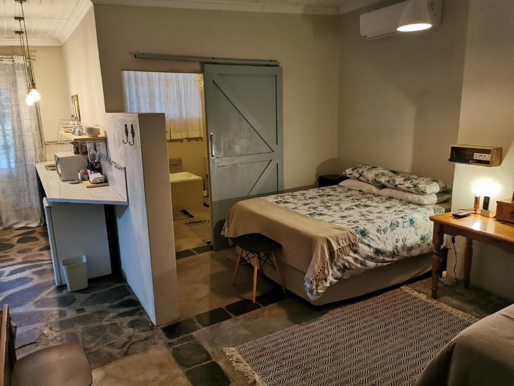 內爾斯普雷特的住宿－MacNut Bed and Breakfast，一间小卧室,配有一张床、一张桌子和一张桌子