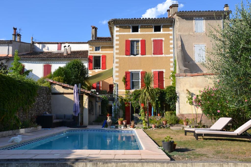 ein Haus mit einem Pool vor einem Gebäude in der Unterkunft St Jean du Gard : Spacious Apartment with Use of Pool in Saint-Jean-du-Gard