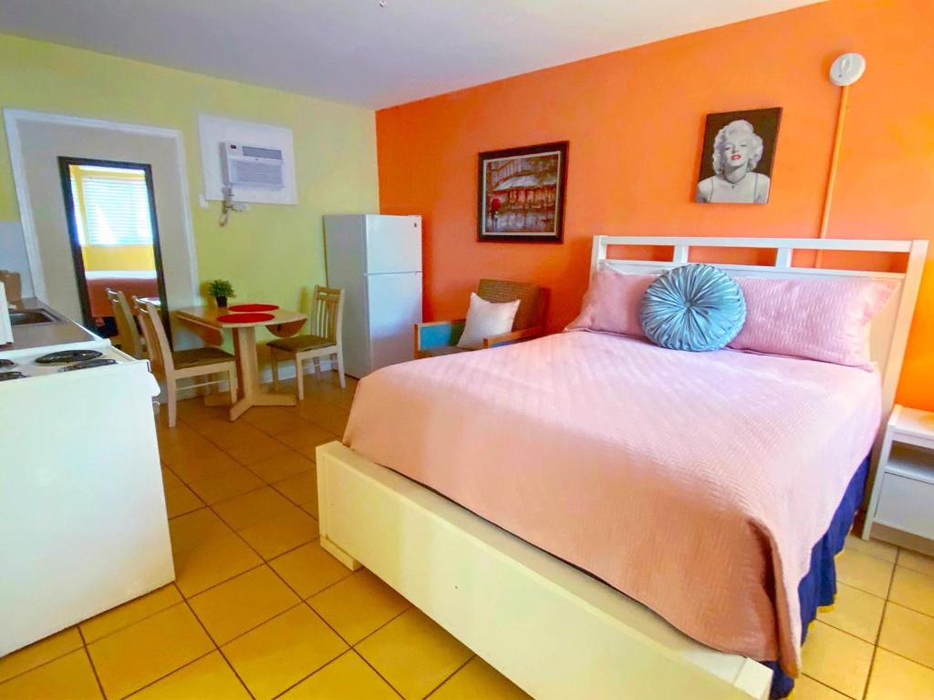 una camera con un grande letto con una parete arancione di Bella Sirena Inn a St Pete Beach