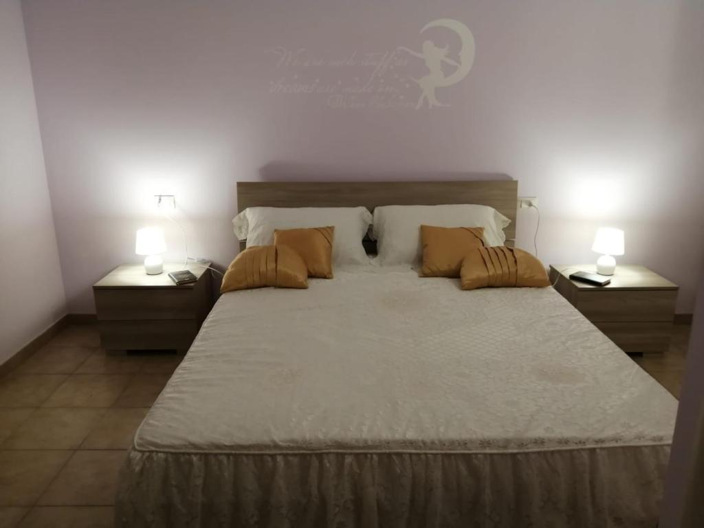 a bedroom with a large bed with two night stands at Appartamento centralissimo in Castellammare del Golfo