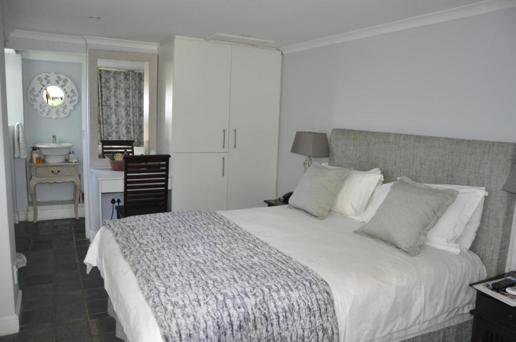 a bedroom with a bed and a desk and a chair at 268 On Ridge Guesthouse in Durban