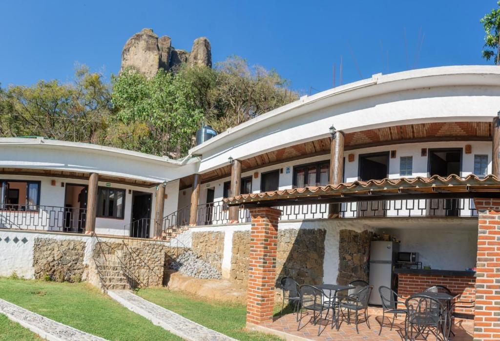 a house with a patio with tables and chairs at Hostal Maria Tepozteca in Tepoztlán