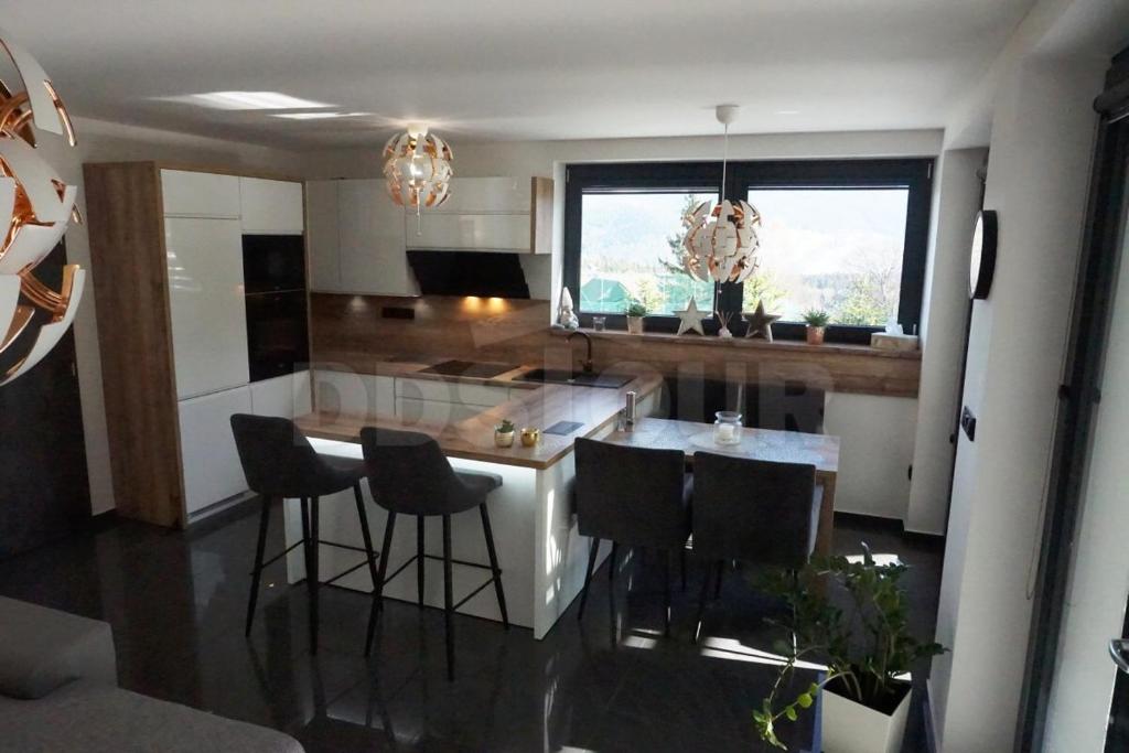 a kitchen with a island with black bar stools at Nad Vyhlídkou - Filipovice in Bělá pod Pradědem