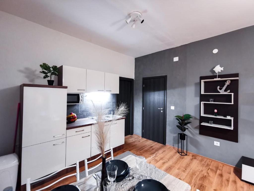 a kitchen with white cabinets and a table in a room at Apartments & Studio Pekica in Rovinj