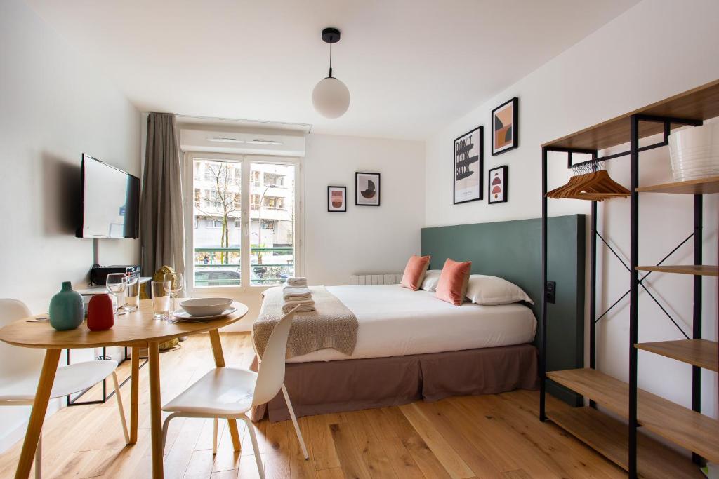 um quarto com uma cama, uma mesa e uma secretária em Amazing studio 2P - Buttes Chaumont em Paris