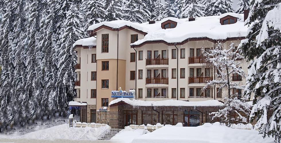 un edificio ricoperto di neve con alberi innevati di Enjoy Studios and Lovely Apartment Villa Park a Borovets