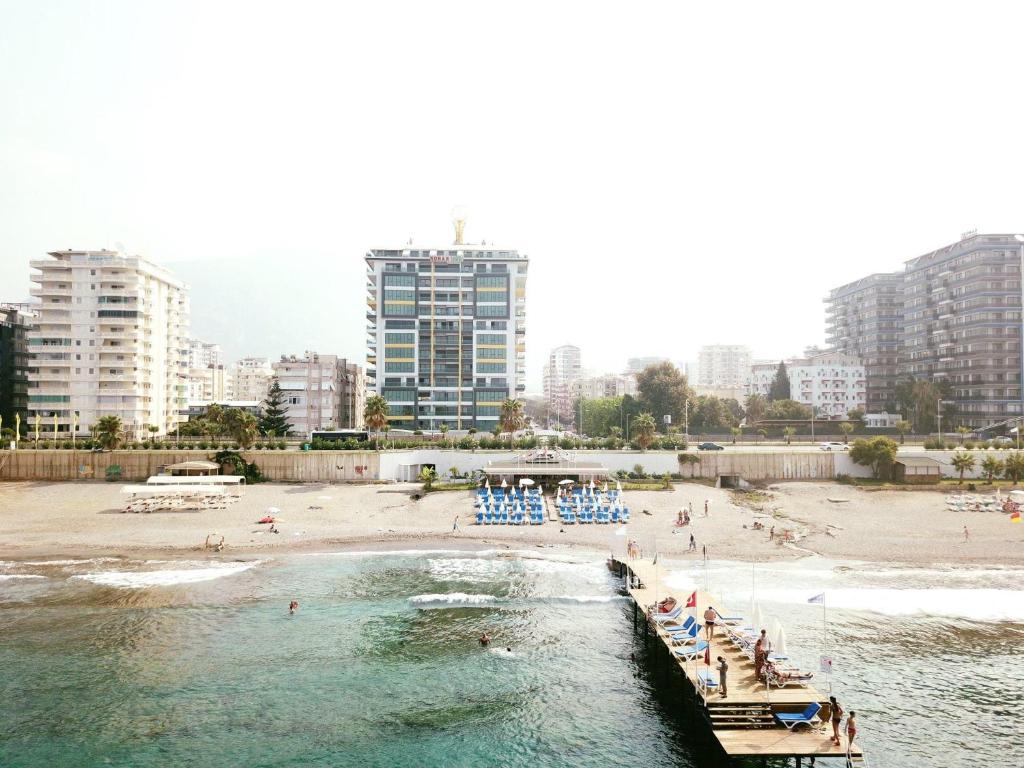 a beach with a pier and people in the water at Konak seaside Tower-King's apartments in Mahmutlar