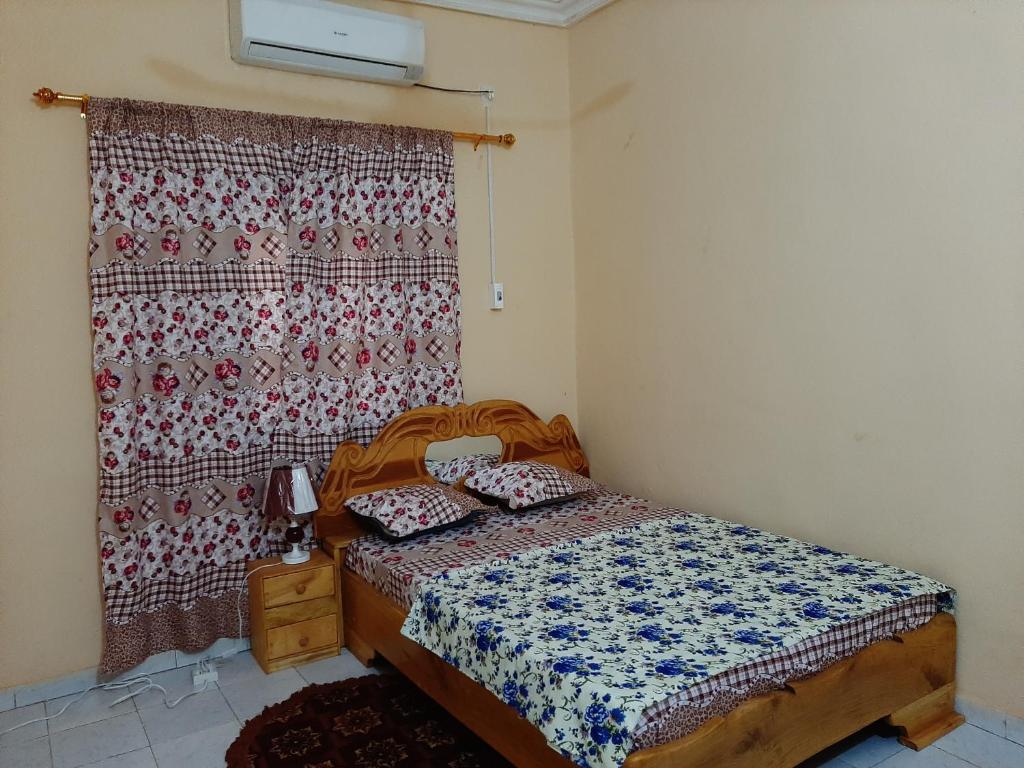 Habitación pequeña con cama y cortina en Villa Chambre C climatisée douche Cuisine salon en Bamako