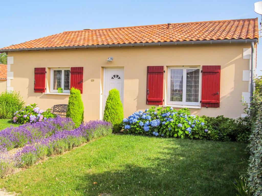 ein Haus mit roten Fensterläden und lila Blumen in der Unterkunft Attractive villa with swimming pool in Les Forges in Les Forges