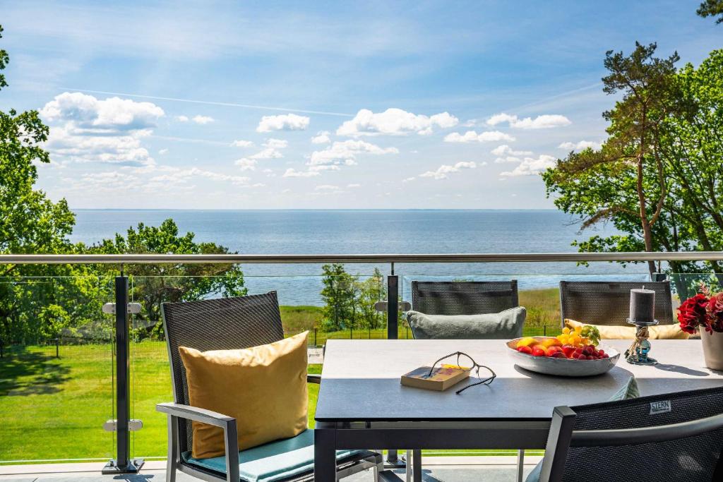 un tavolo e sedie su un balcone con vista sull'oceano di Appartement "AUSZEIT" mit Penthouseflair - Oase am Haff a Garz