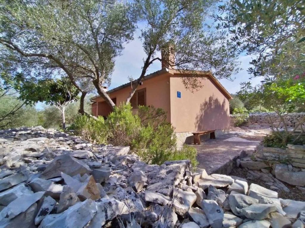 a house in the middle of a pile of rocks at Holiday home Nature park - relaxing and comfortable in Sali