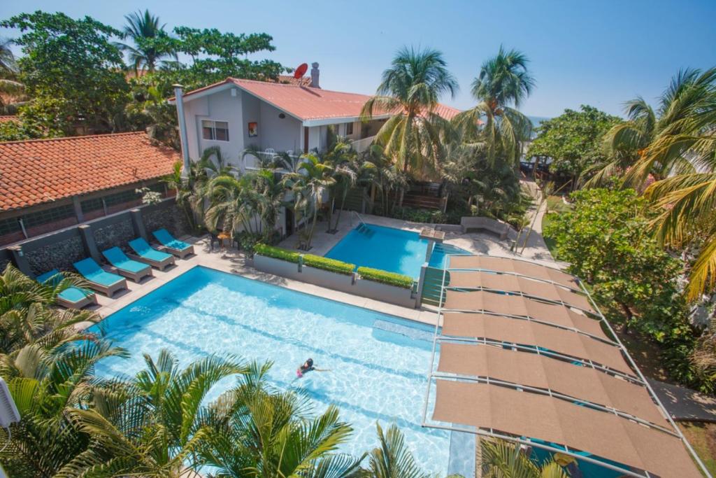 una vista aérea de una casa con piscina y palmeras en Hotel Roca Sunzal, en La Libertad