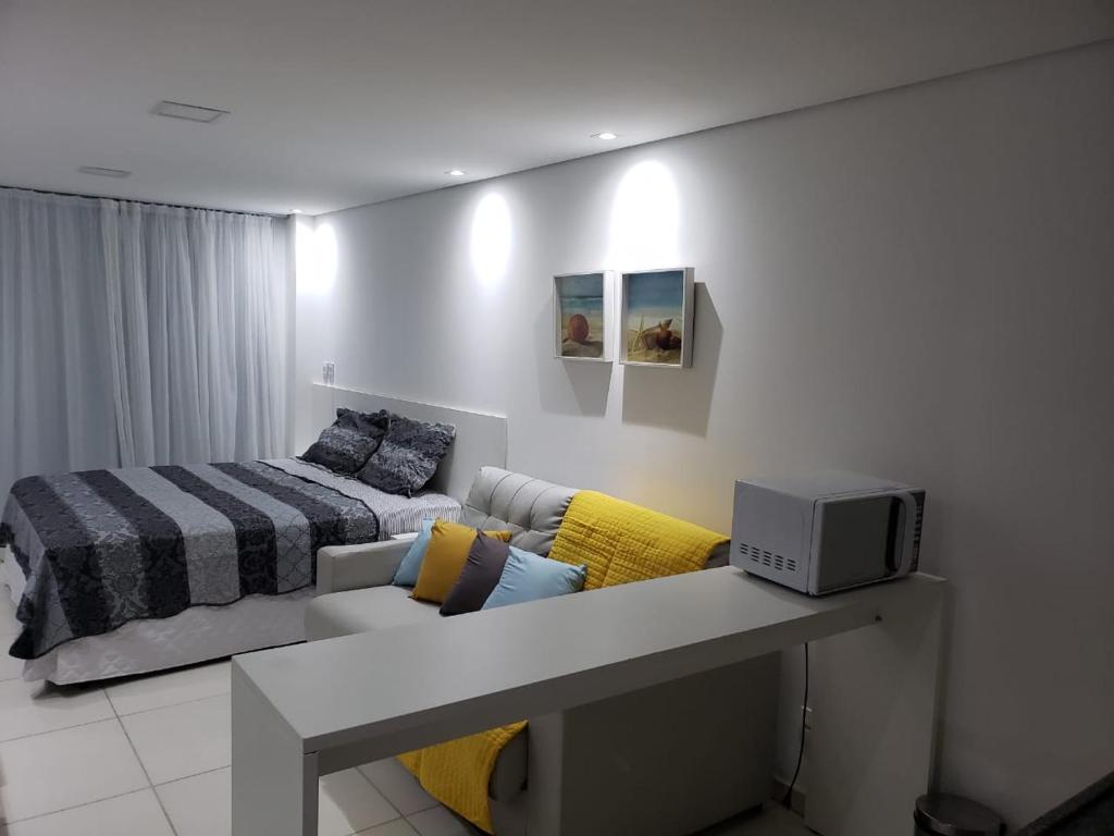 uma sala de estar com um sofá e uma cama em Laguna Beach Flat 314- Porto de Galinhas em Porto de Galinhas