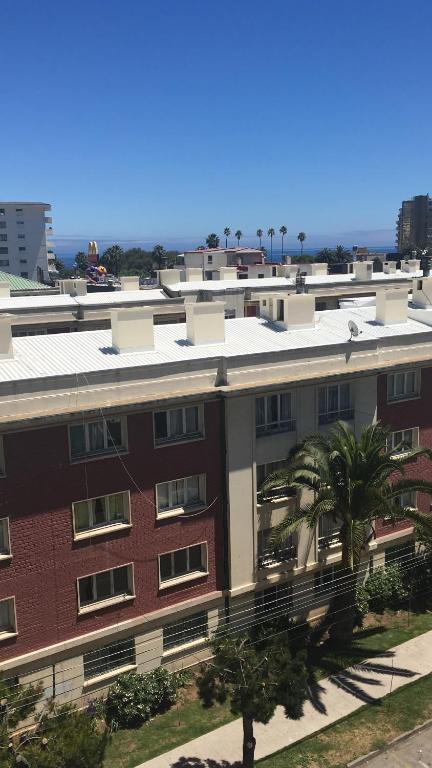 a red brick building with palm trees in front of it at Viña del Mar frente Casino- Departamento 3 norte in Viña del Mar