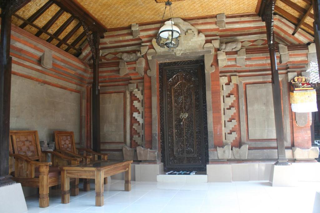 una habitación con bancos y una puerta en un edificio en Nugraha Guesthouse 1, en Ubud