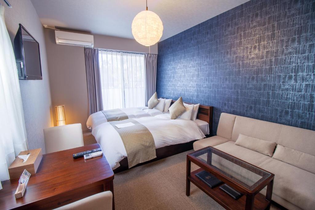 a hotel room with a bed and a couch at Stay SAKURA Kyoto Fuga in Kyoto