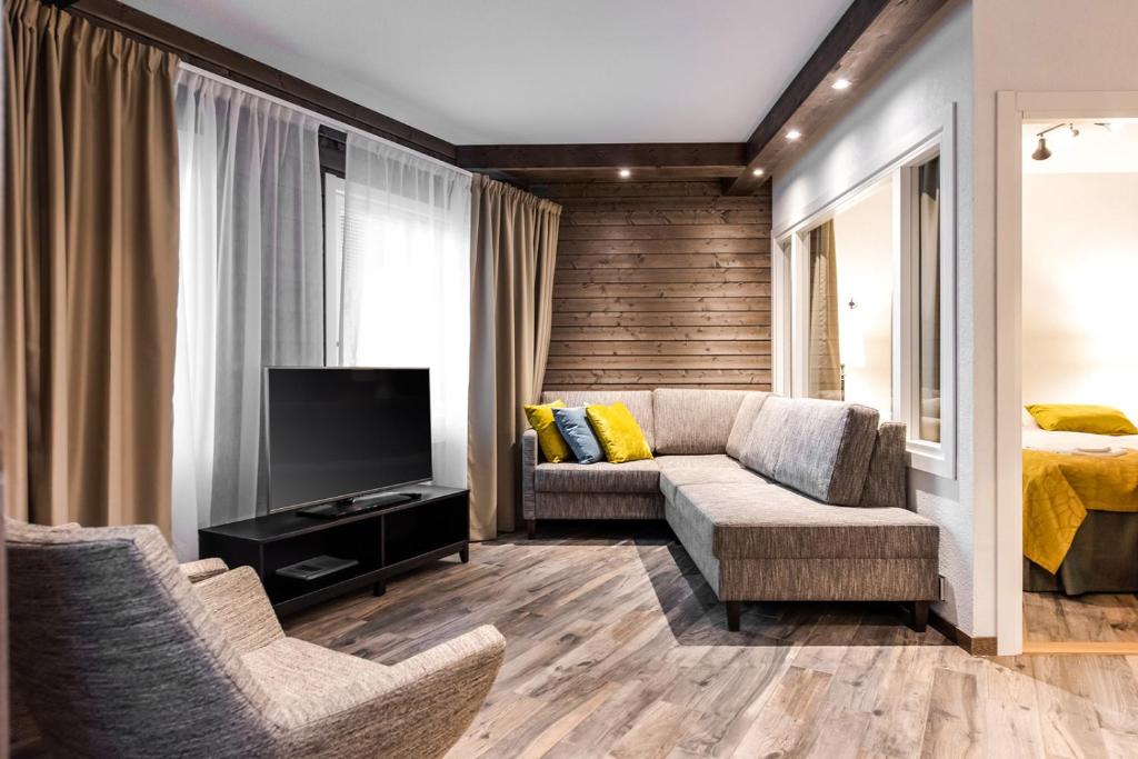 un soggiorno con un divano e una TV di RukaValley Unique75 a Ruka