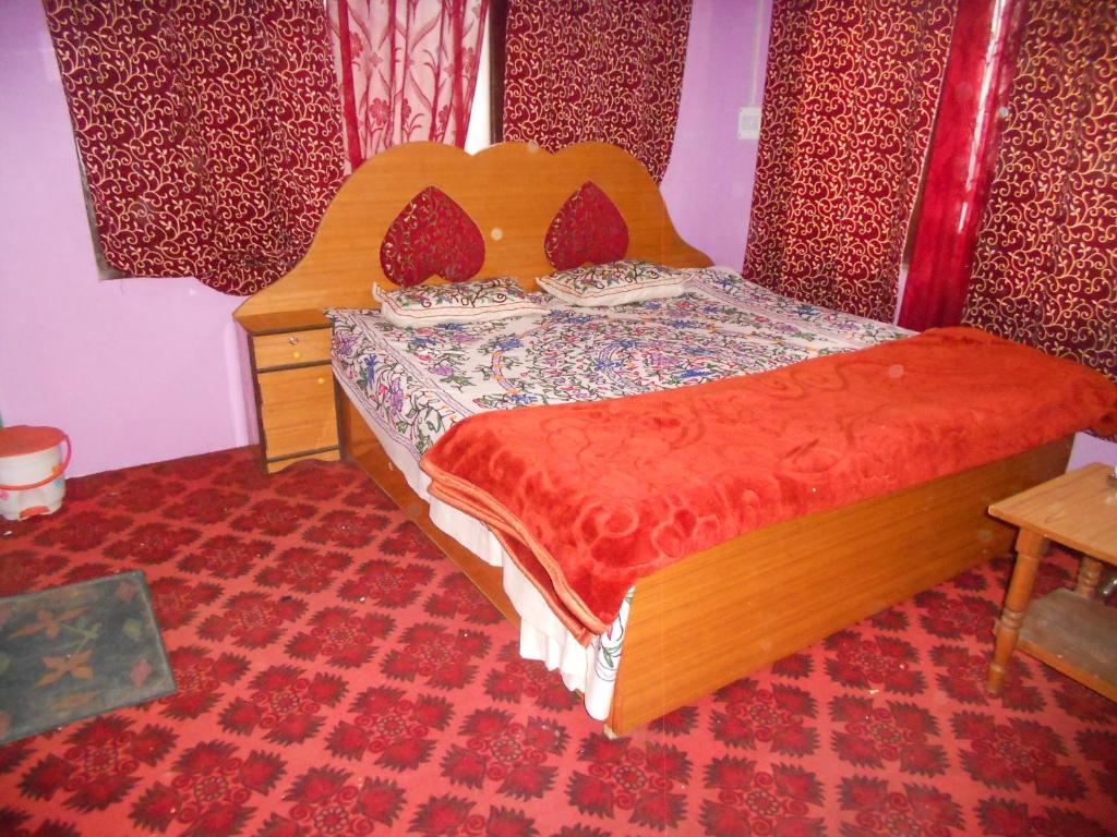 a bedroom with a bed with a wooden head board at Alamdar guest house in Srinagar