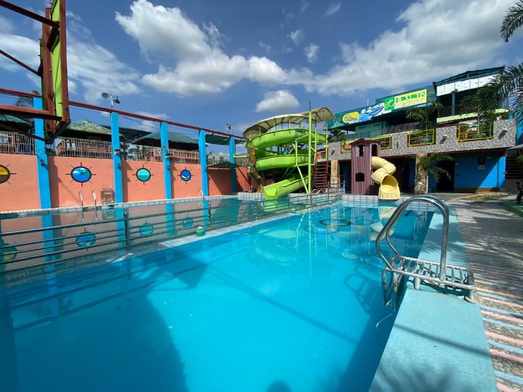 une grande piscine avec un toboggan dans l'établissement RedDoorz Plus @ Lhexlyn Resort San Narciso, à San Narciso