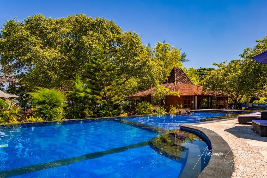 uma grande piscina azul com uma casa ao fundo em Oceans 5 Dive Resort em Gili Air
