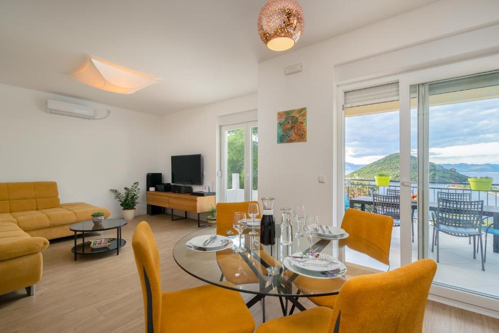VILA ROZA في Prožura: غرفة معيشة مع طاولة زجاجية وكراسي صفراء