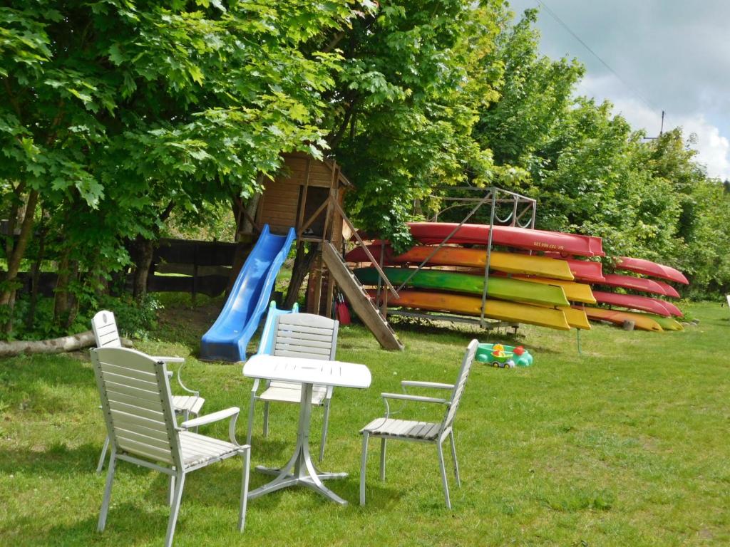 a park with chairs and a playground with a slide at Domki - Mazurski Zaścianek in Kruklanki