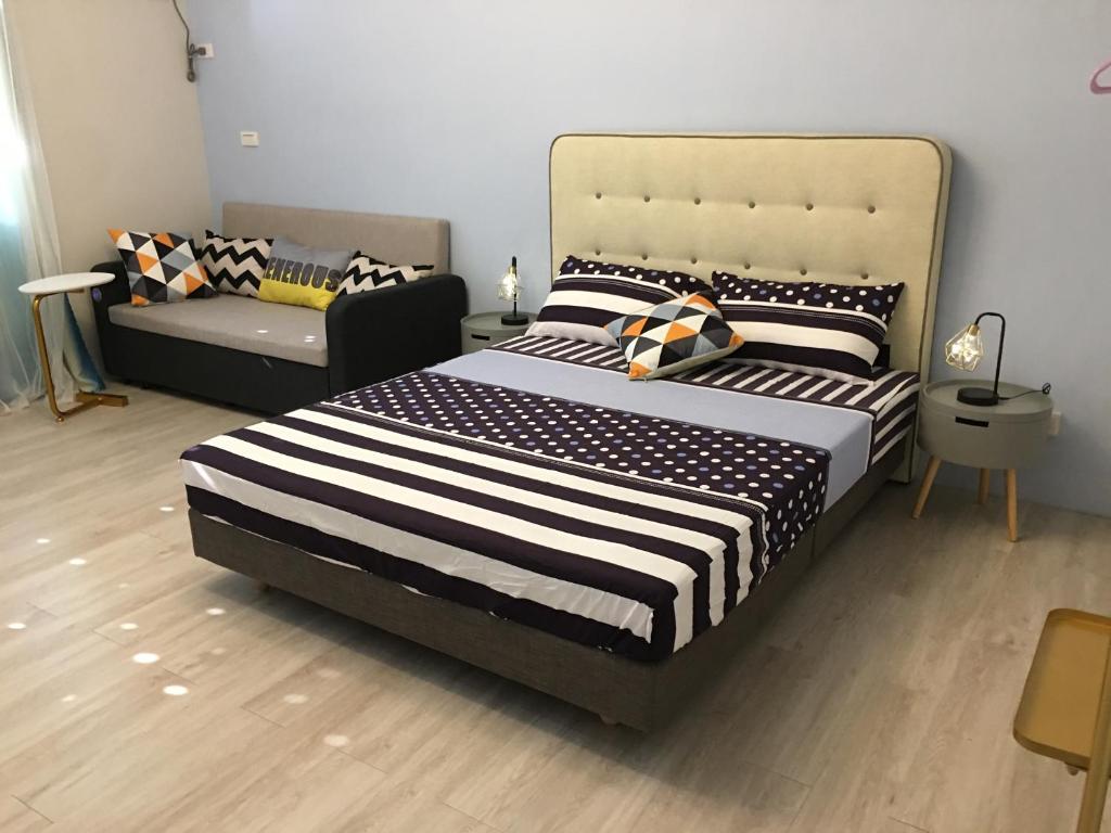 1 dormitorio con 1 cama grande y 1 sofá en ㄧ個背包客棧, en Chu-nan-ts'un