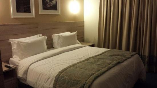 a bedroom with a large bed with white sheets and pillows at Suites Metrô Luz in Sao Paulo
