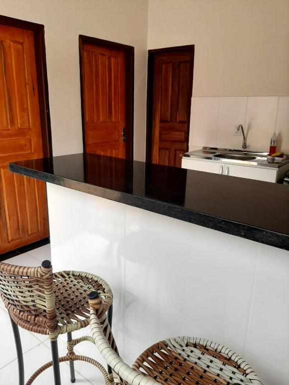 a kitchen with a black counter top and a chair at Casa de dois quartos in Carolina