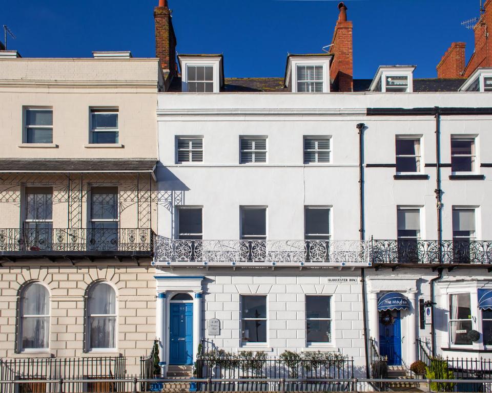 a white house with blue doors and windows at No. 98 Boutique Hotel in Weymouth