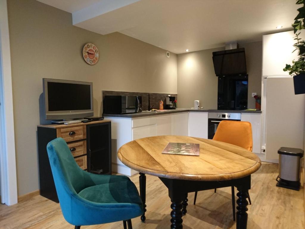 une cuisine avec une table et des chaises et une télévision dans l'établissement Appartement Belle Vue, à Gérardmer