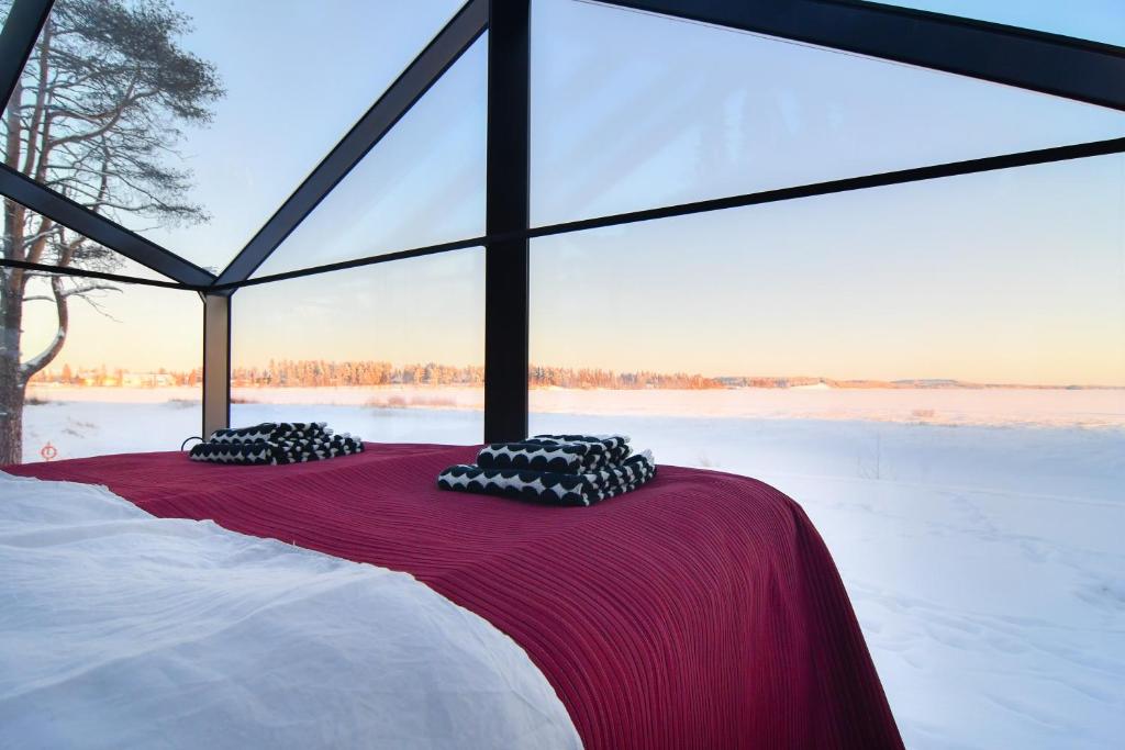 a bed with two pillows on it in a snowy room at Arctic Lakeland Igloos Vuokatti in Vuokatti