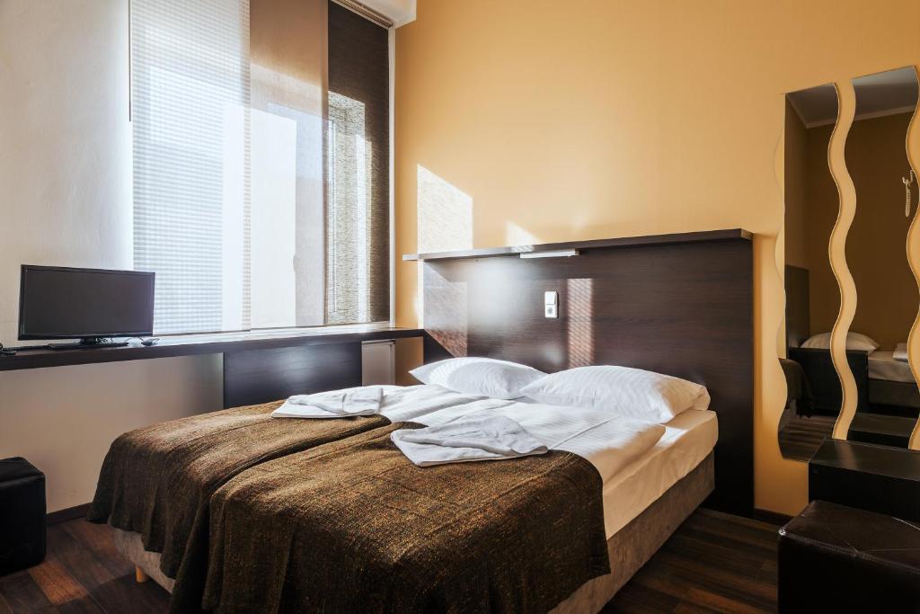 Postel nebo postele na pokoji v ubytování Apple City Hotel