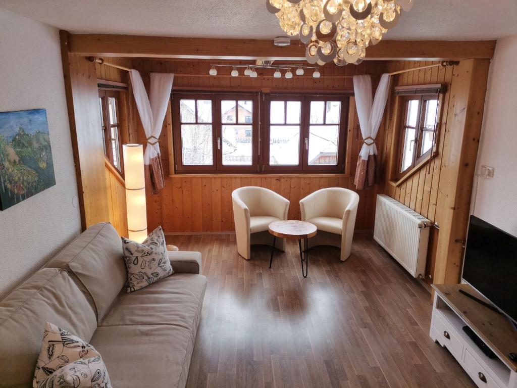 a living room with a couch and chairs and a television at Landhaus Kulm in Bad Mitterndorf