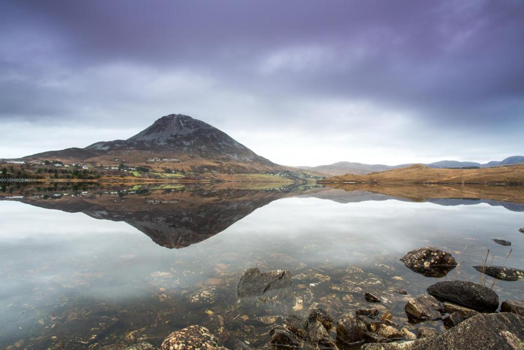 een berg die reflecteert in het water van een meer bij Suaimhneas in Falcarragh