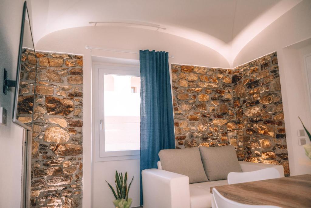 een woonkamer met een stenen muur bij Appartamento Mare in La Caletta