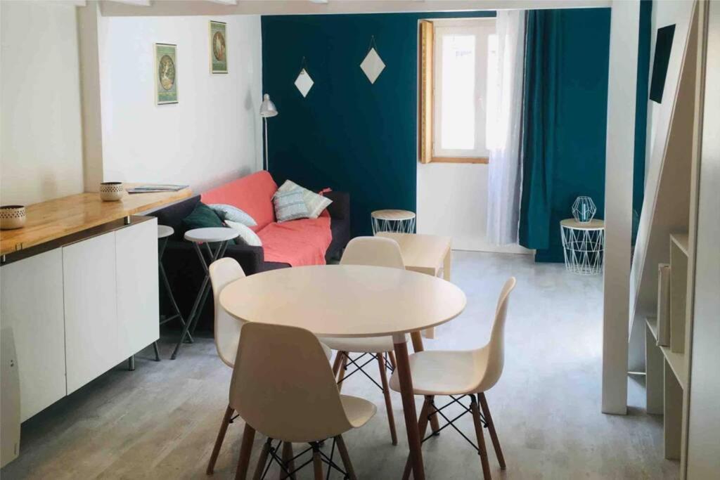 - un salon avec une table et un canapé rouge dans l'établissement Cosy à Guist'hau, à Nantes